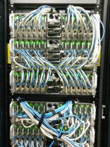 front of a rack, with servers in it and lots of cables